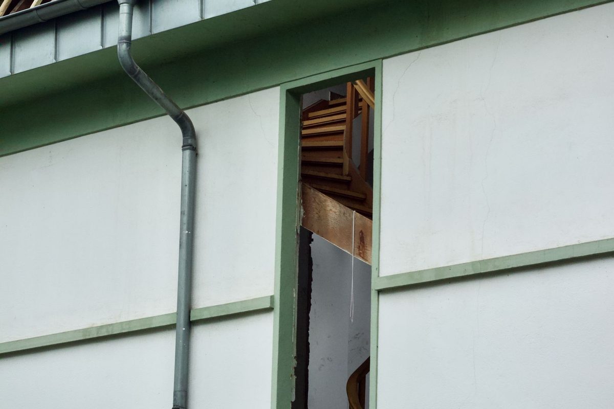 A storm-damaged roof with a torn opening exposing the framing, the kind of emergency storm and flood damage restoration responds to